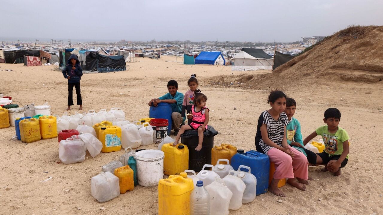 Displaced Palestinian children wait for water at their tent camp in Rafah -- the UN children's agency estimates the war has displaced around 850,000 children in Gaza