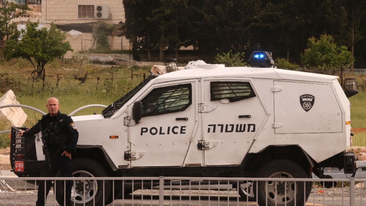 An Israeli policeman cordons off the Beit Einun junction area, after the latest deadly incident in the Israeli-occupied West Bank