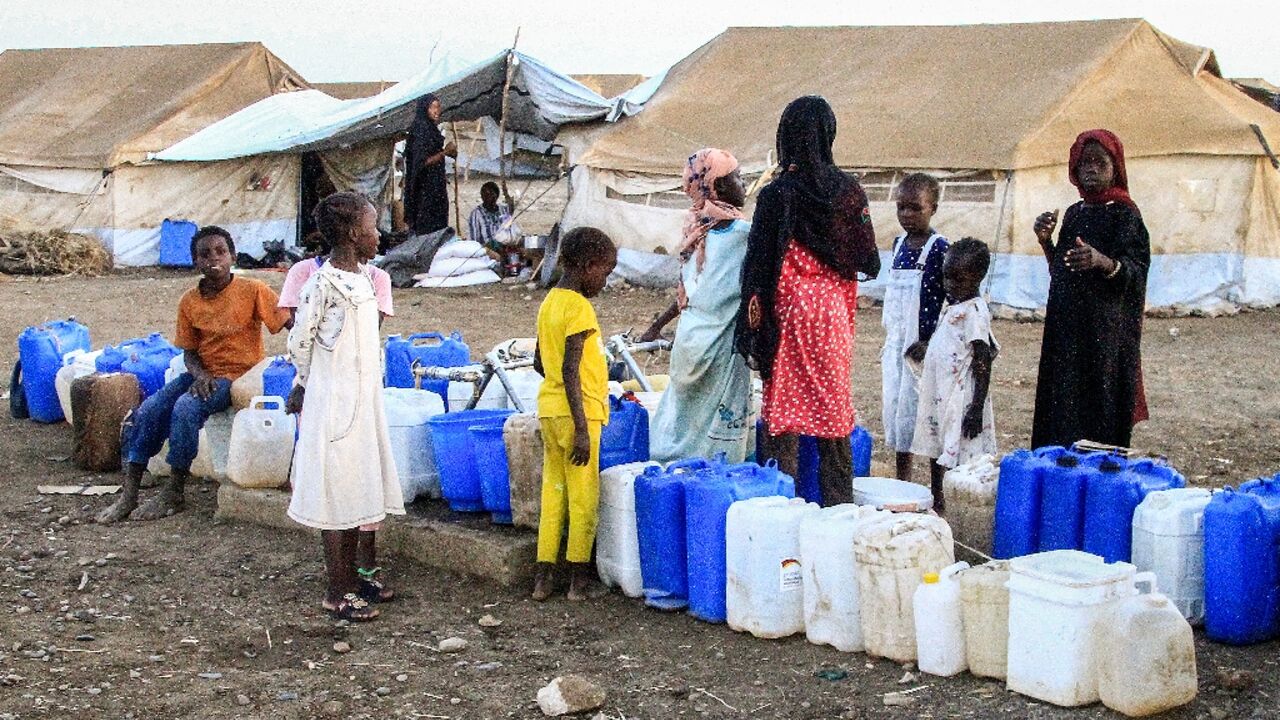 Women and children queue for water at Huri camp for the displaced south of Gedaref in east Sudan, on March 29 Women and children queue for water at Huri camp for the displaced south of Gedaref in east Sudan, on March 29