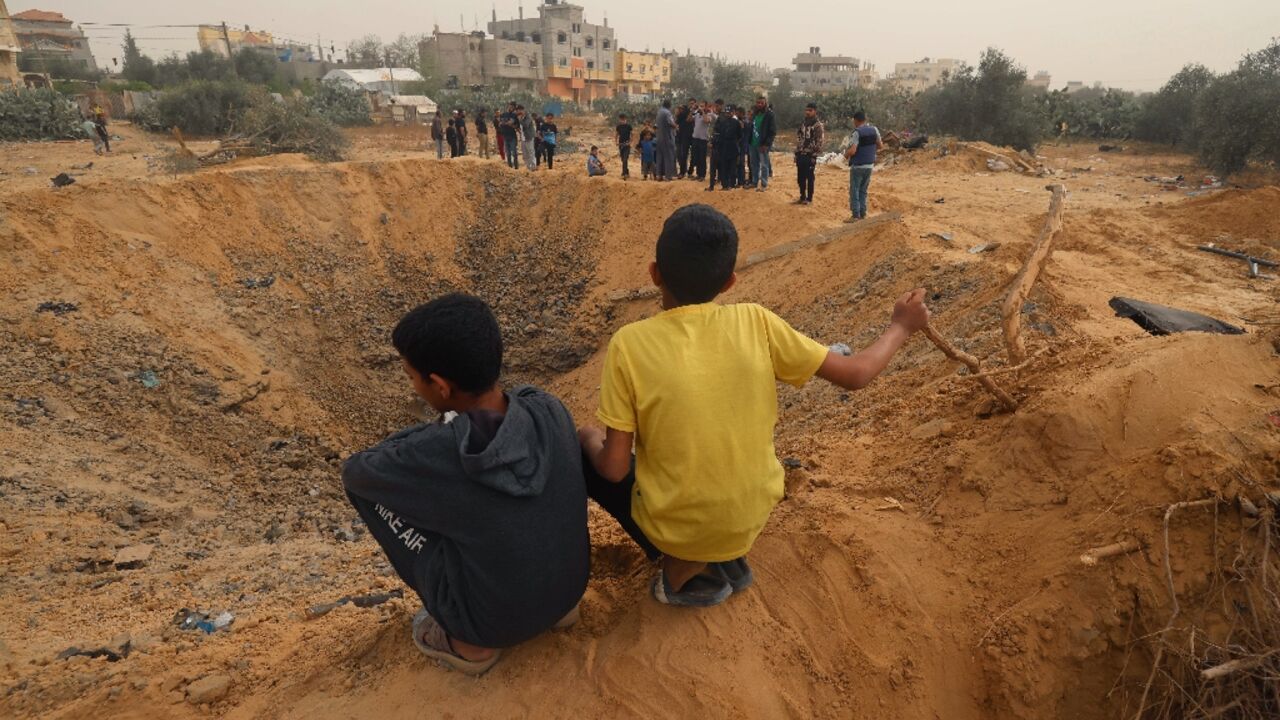 Two Palestinian boys look at a huge crater following an overnight Israeli bombardment in Rafah, southern Gaza Strip Two Palestinian boys look at a huge crater following an overnight Israeli bombardment in Rafah, southern Gaza Strip