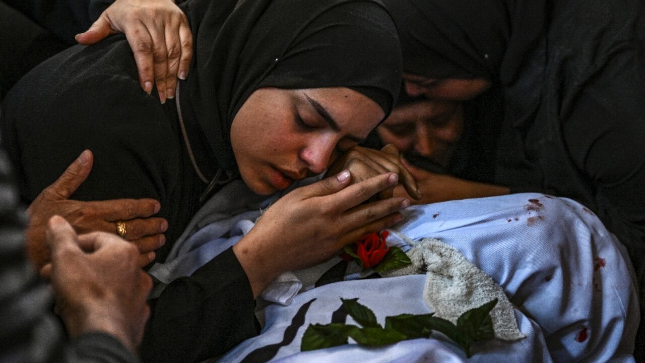 A funeral procession for 13 Palestinians killed in the Israeli army raid passed through roads piled with rubble