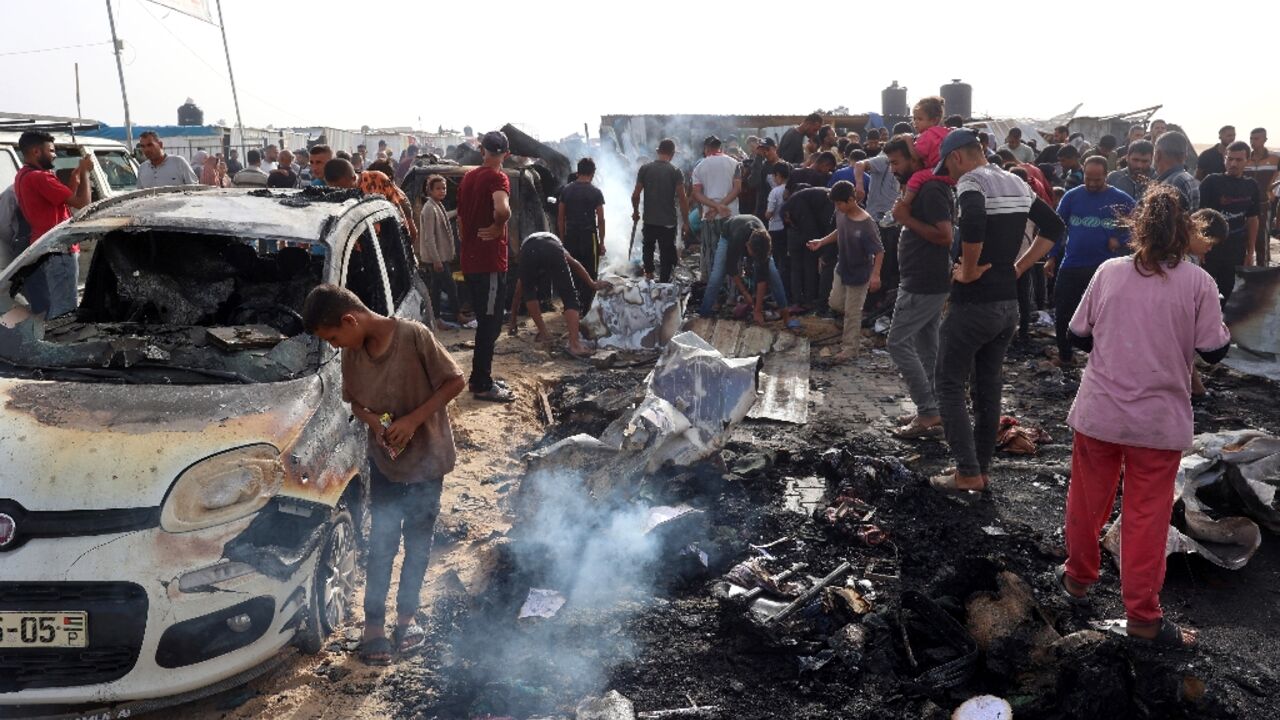 Palestinians gather at the site of the Israeli strike on the camp for displaced people Palestinians gather at the site of the Israeli strike on the camp for displaced people