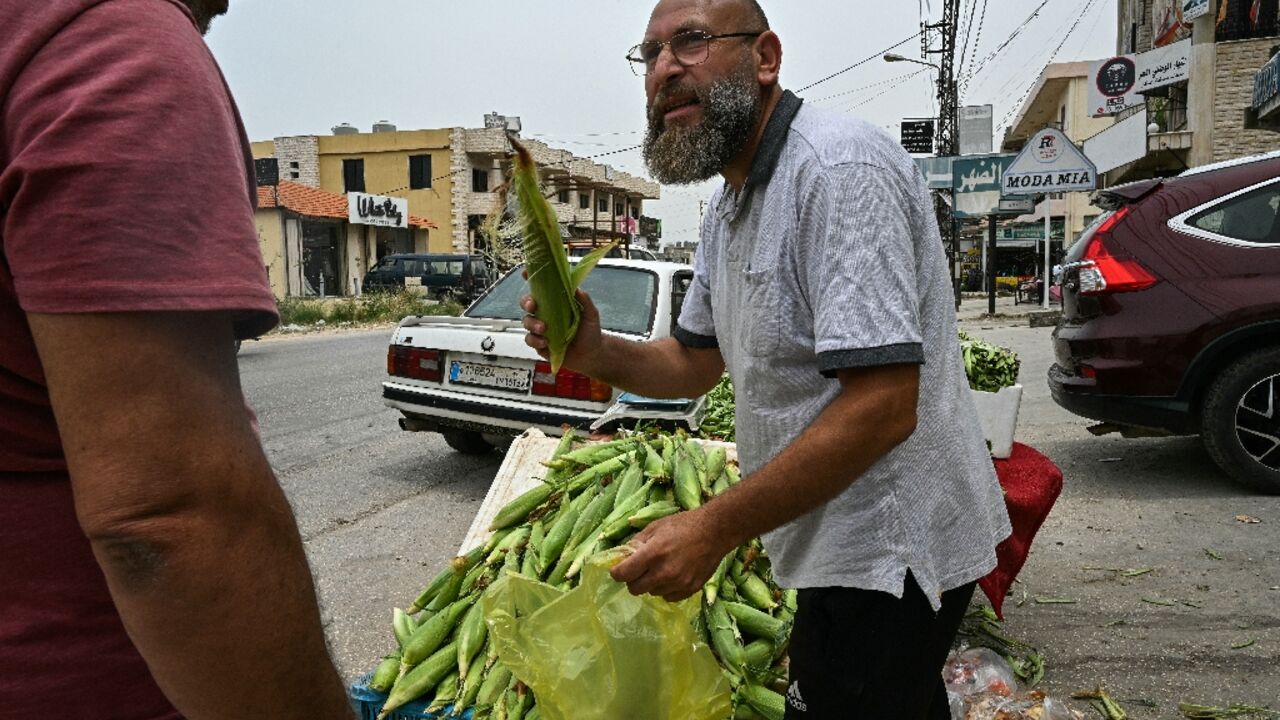 Syrian refugee Hassan Jaber al-Salloum sells vegetables at the roadside in the Lebanese village of Minyara