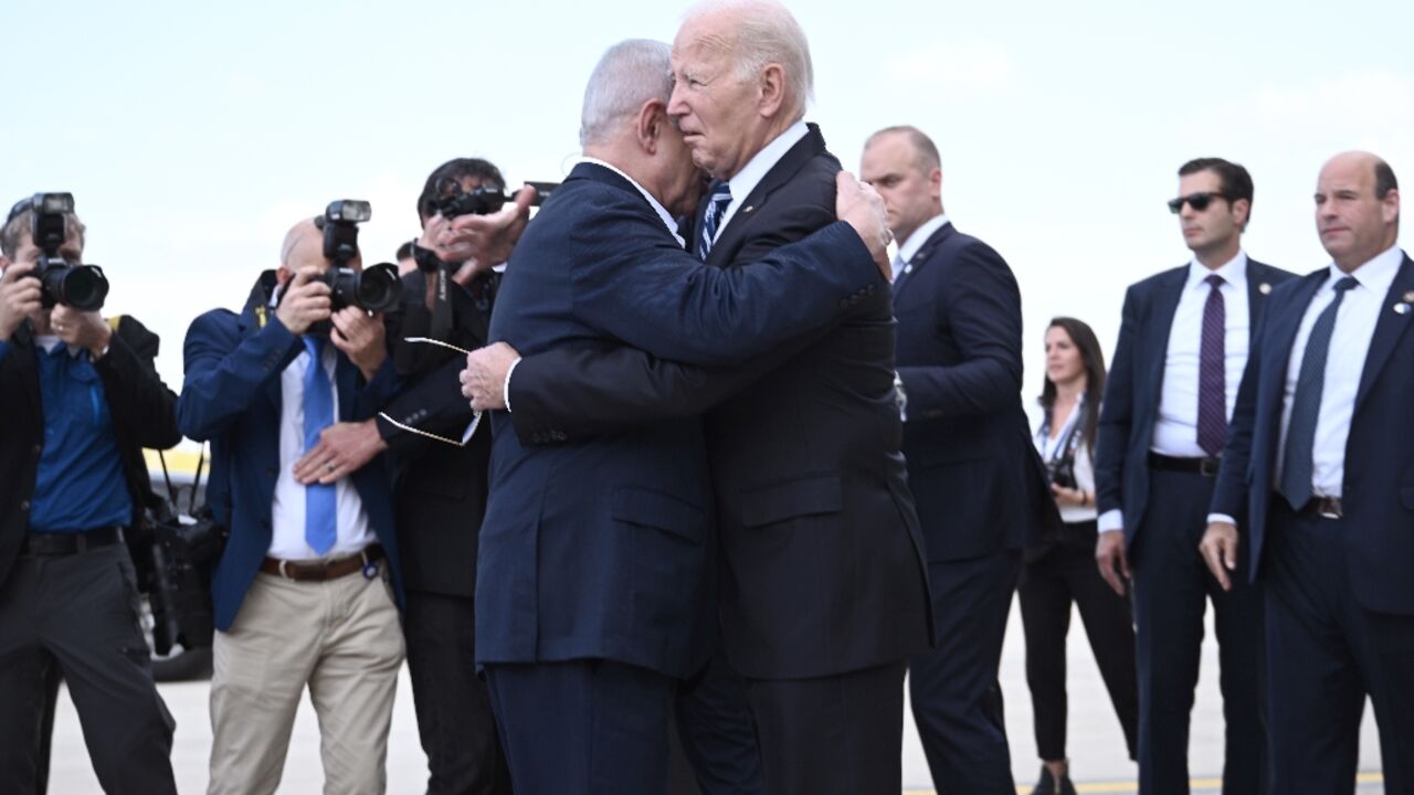 Israel Prime Minister Benjamin Netanyahu hugs US President Joe Biden upon his arrival at Tel Aviv's Ben Gurion airport on October 18, 2023