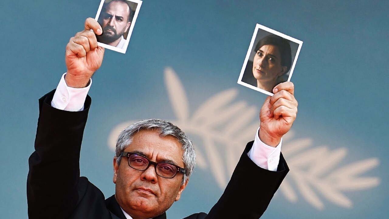 Rasoulof held up pictures of his actors Soheila Golestani and Missagh Zareh at the premiere Rasoulof held up pictures of his actors Soheila Golestani and Missagh Zareh at the premiere