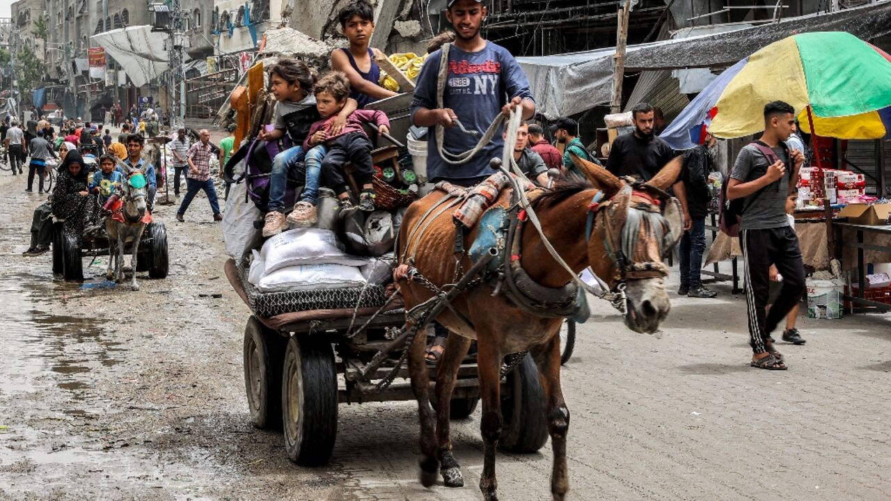 A man flees with children and belongings from the Jabalia camp for Palestinian refugees in the northern Gaza Strip on May 11, 2024 