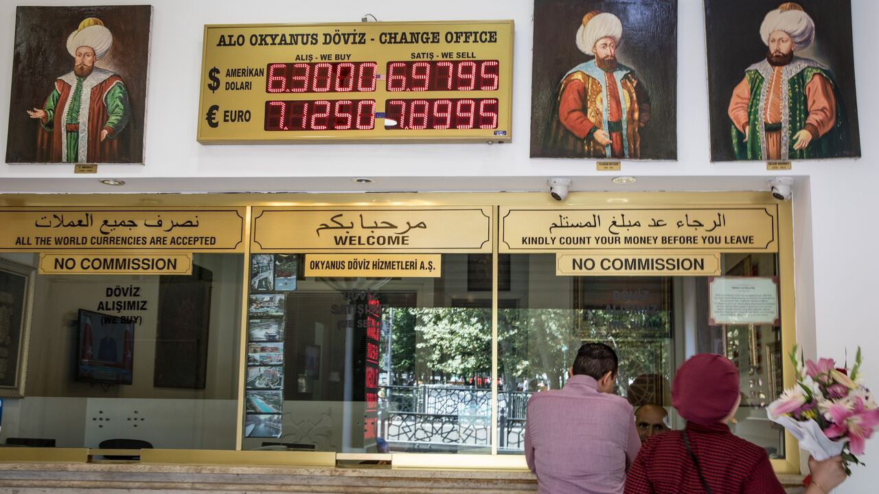 People exchange money at a currency exchange office on Aug. 13, 2018, in Istanbul, Turkey.