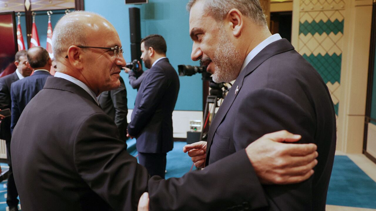 Turkish Treasury and Finance Minister Mehmet Simsek (L) speak with Turkish Foreign Minister Hakan Fidan (R) before the press conference following the cabinet meeting held at the Presidential Complex in Ankara on August 21, 2023. (Photo by Adem ALTAN / AFP) (Photo by ADEM ALTAN/AFP via Getty Images)