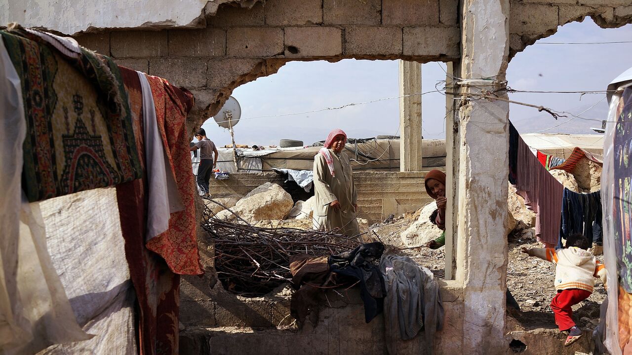 Displaced Syrians walk through a makeshift camp for Syrian refugees only miles from the border with Syria in the Bekaa Valley on Nov. 12, 2013, in Majdal Anjar, Lebanon. 