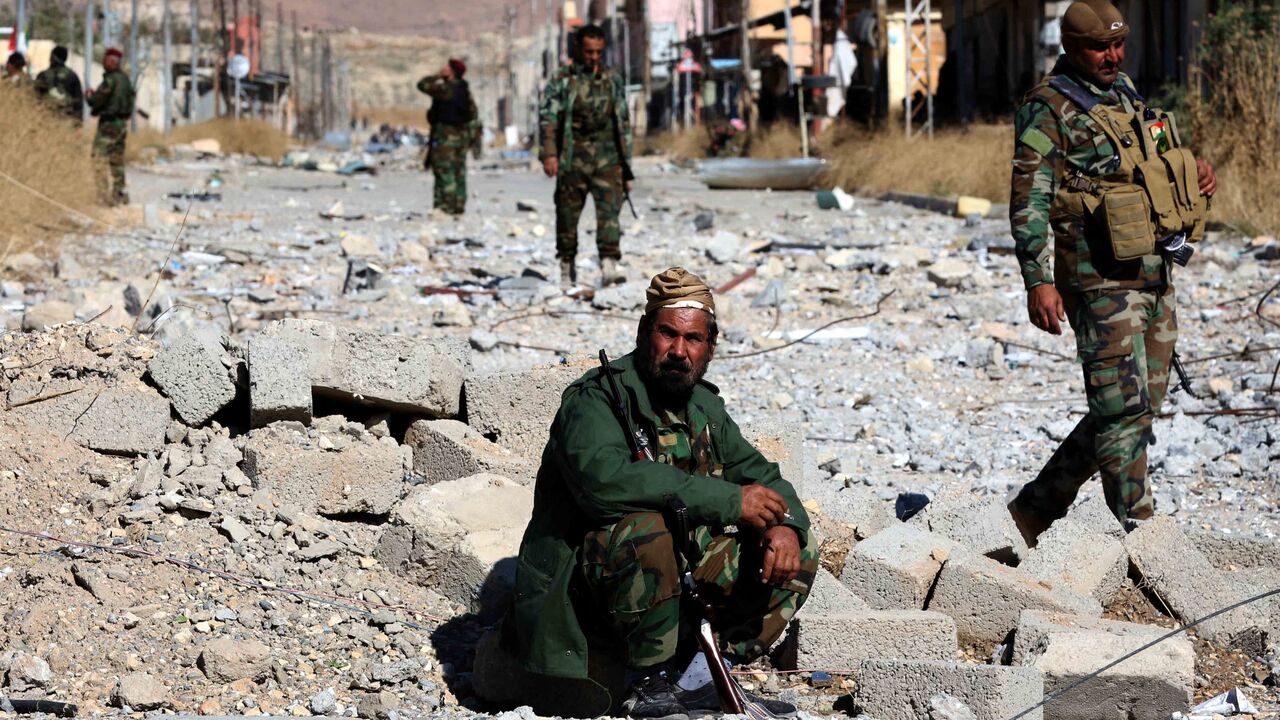 Iraqi autonomous Kurdish region's peshmerga forces and fighters from the Yazidi minority, a local Kurdish-speaking community targeted in a brutal campaign by the Islamic State (IS) group, enter the western Iraqi city of Sinjar, in the Nineveh Province, on Nov. 13, 2015.