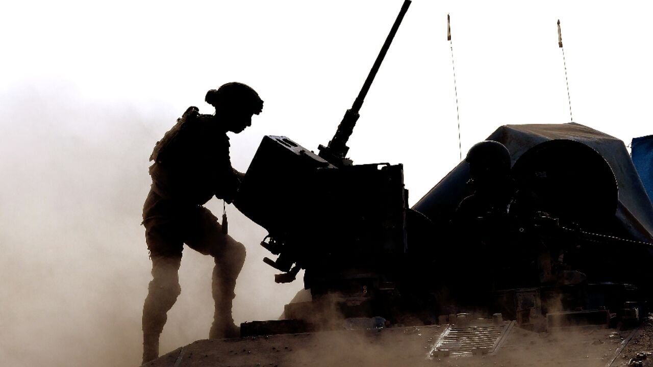 An Israeli soldier operates the gun on a military vehicle near the Israel-Gaza border