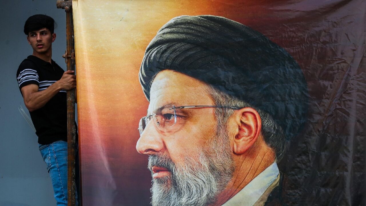 Men hang a huge portrait of Iran's late president Ebrahim Raisi outside the Iranian embassy in Baghdad Men hang a huge portrait of Iran's late president Ebrahim Raisi outside the Iranian embassy in Baghdad