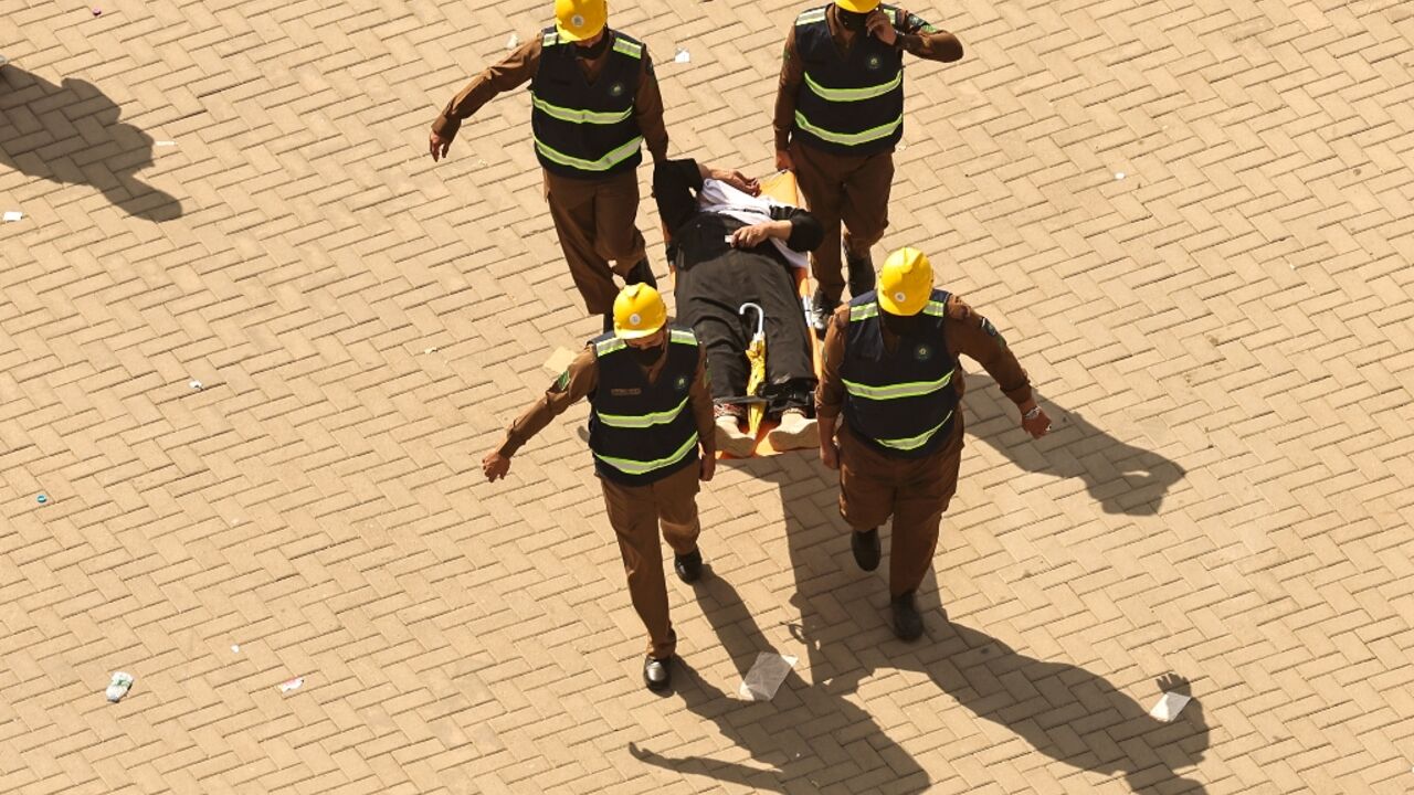 A man affected by scorching heat is stretchered away during the hajj pilgrimage