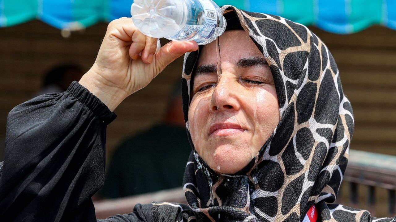 A Turkish pilgrim pours cold water on her head to cool off in Saudi Arabia's holy city of Mecca A Turkish pilgrim pours cold water on her head to cool off in Saudi Arabia's holy city of Mecca
