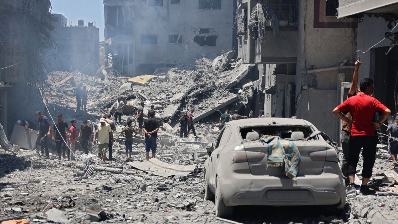 People inspect the damage after Israeli bombardment of the al-Shati refugee camp in Gaza City on June 22, 2024