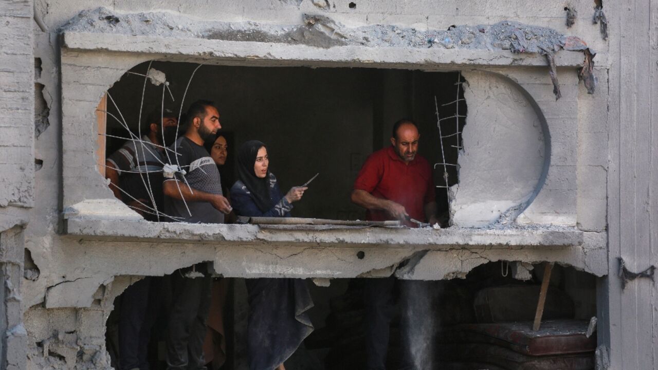 Palestinians at a damaged apartment block following overnight Israeli strikes in Bureij refugee camp in the central Gaza Strip