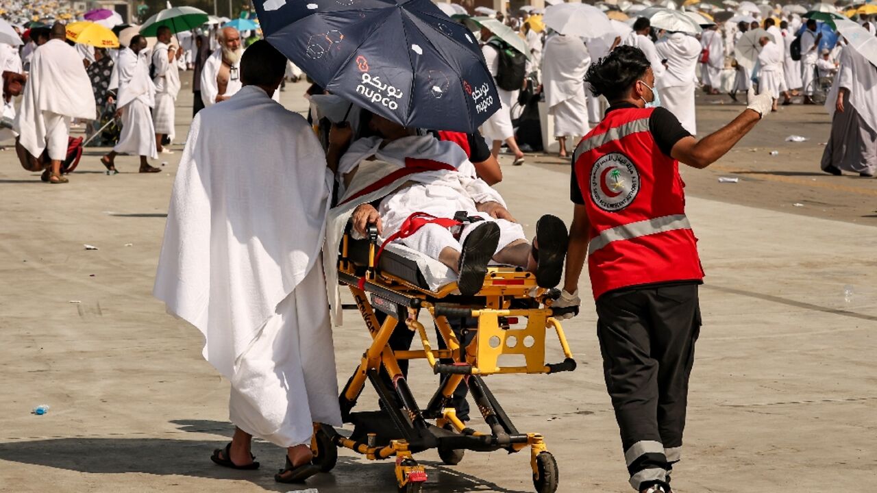 Medical team members evacuate a Muslim pilgrim, affected by the soarching heat, at the base of Mount Arafat, also known as Jabal al-Rahma or Mount of Mercy, during the annual hajj pilgrimage on June 15, 2024