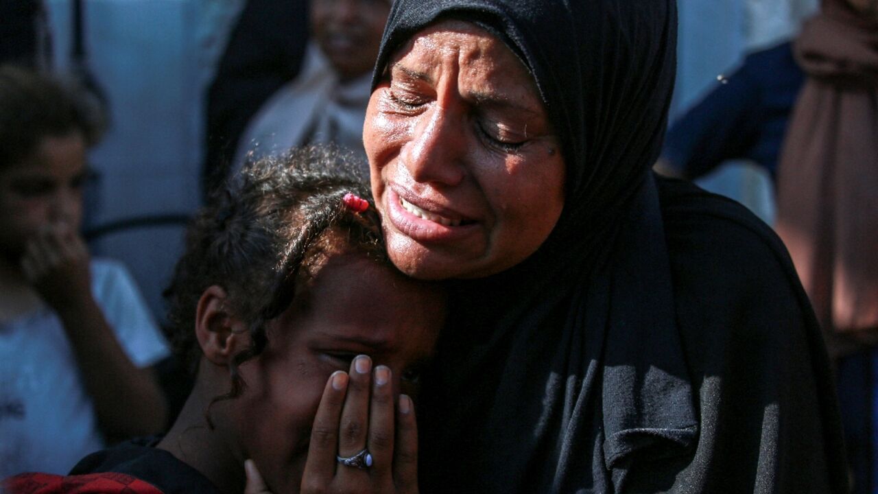 A Palestinian woman and a child cry as they mourn the death of a loved one outside a hospital in central Gaza A Palestinian woman and a child cry as they mourn the death of a loved one outside a hospital in central Gaza