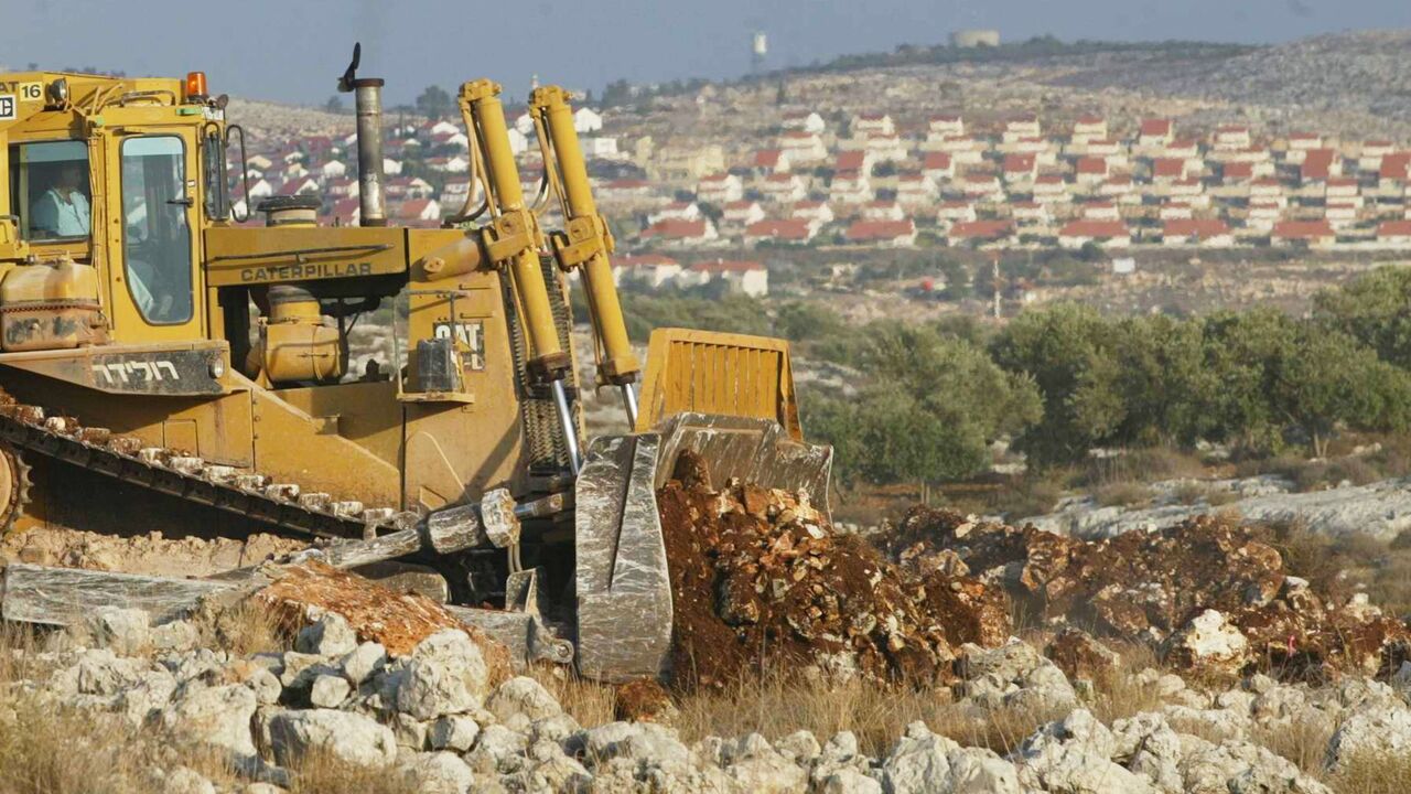 Israeli tractors prepare the ground for a new section of the Israel's security fence on November 12, 2003.