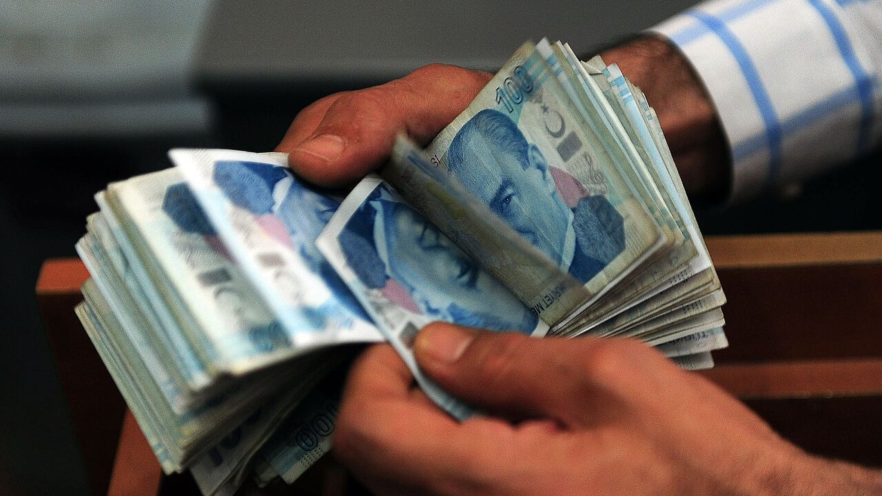 An exchange office worker counts Turkish lira banknotes in Istanbul, June 8, 2015.