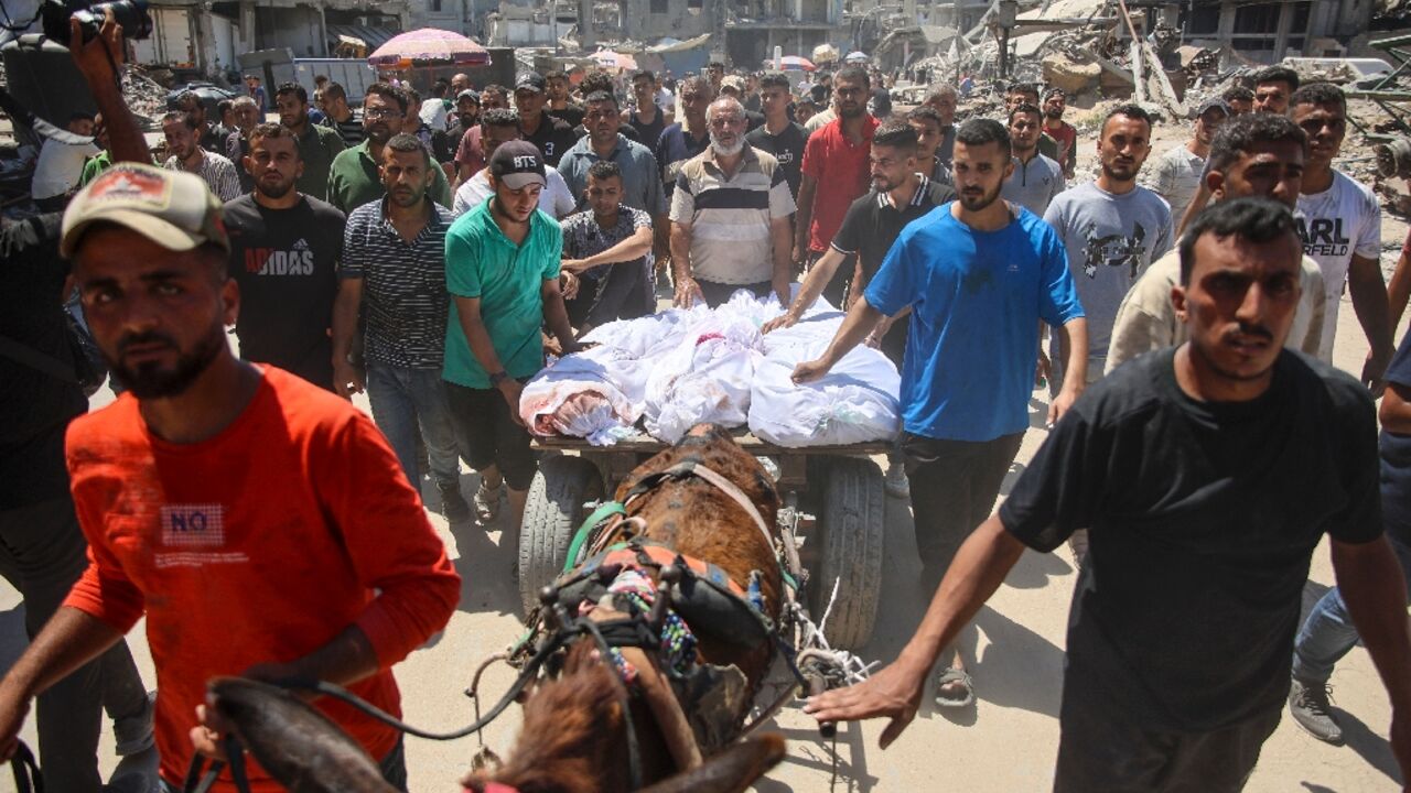 Palestinians transport the bodies of loved ones killed during Israeli bombardment of Gaza City's Al-Tuffah neighbourhood