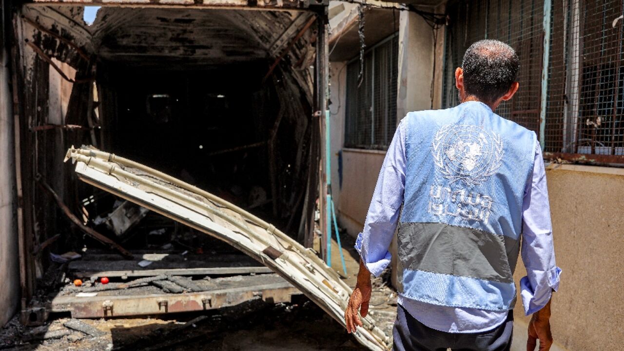 A UN worker inspects the remains of a container hit by Israeli bombardment at a school in Gaza's Al-Shati refugee camp A UN worker inspects the remains of a container hit by Israeli bombardment at a school in Gaza's Al-Shati refugee camp