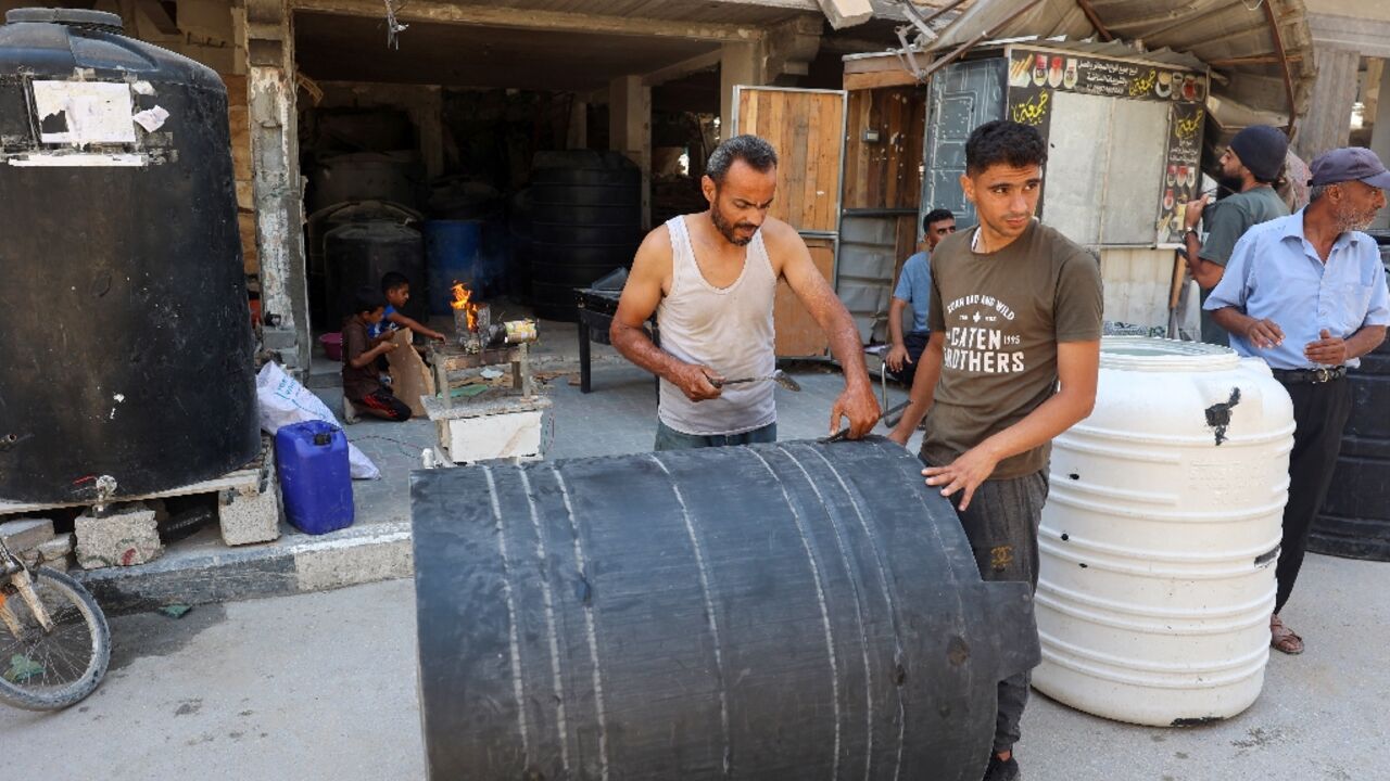 A man repairs water tanks damaged during Israeli bombardment in the southern Gaza Strip A man repairs water tanks damaged during Israeli bombardment in the southern Gaza Strip