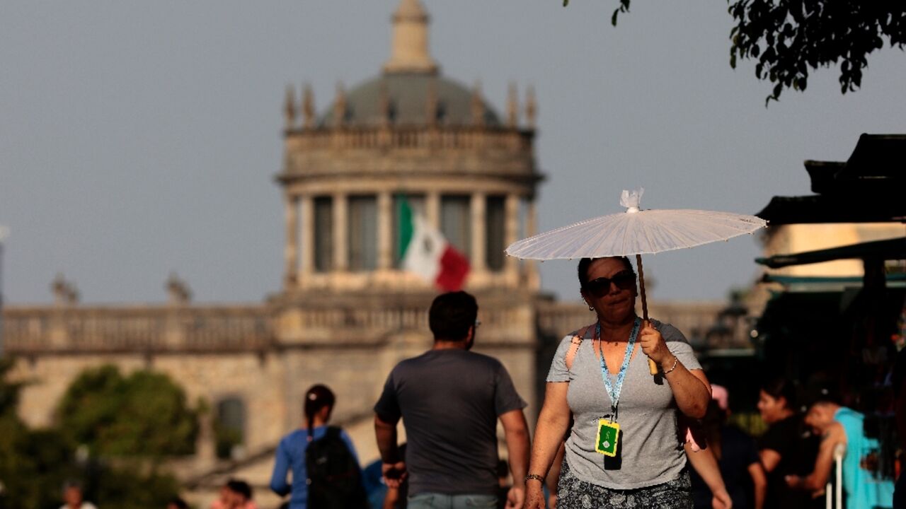 People protect themselves from the sun during a heat wave hitting the country, in Guadalajara, Jalisco state, Mexico, in May 2024