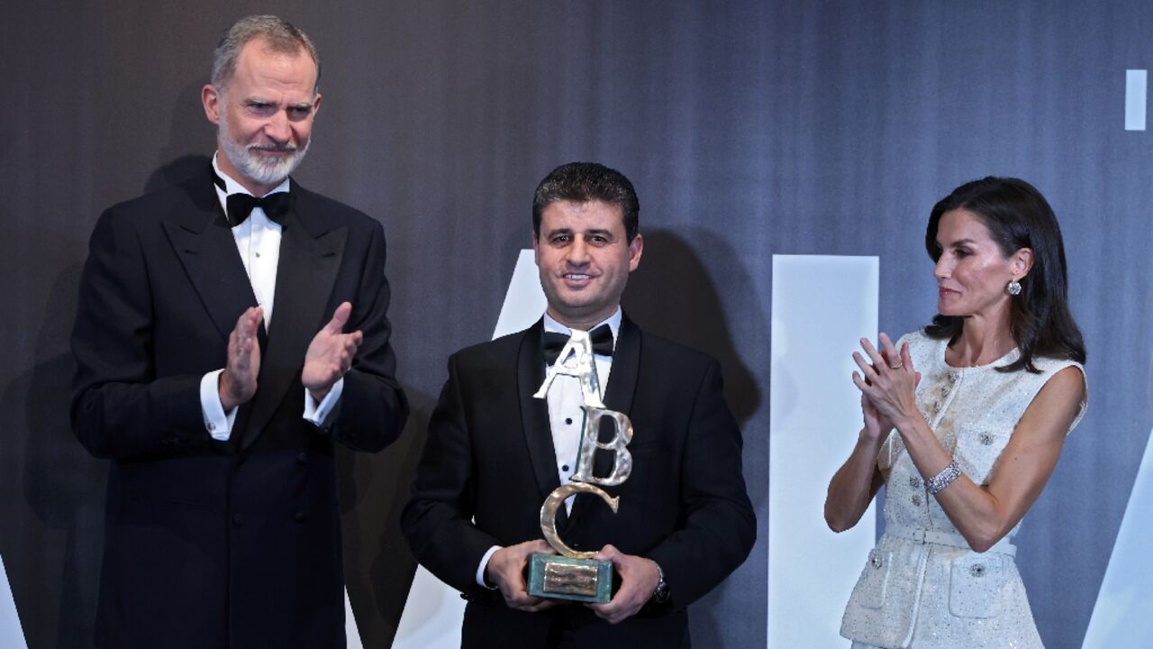 King of Spain Felipe VI (L) and Queen of Spain Letizia present Spain's prestigious Mingote Prize to AFP Palestinian photographer from the Gaza Strip Said Khatib (C), a Palestinian photojournalist from the Gaza Strip