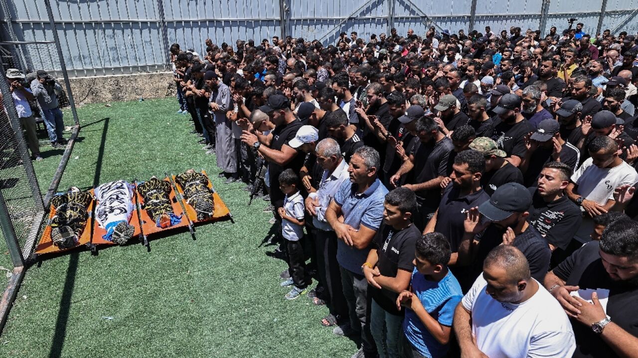 Mourners and gunmen at the funeral of four Palestinian militants killed in an Israeli airstrike on a refugee camp in the occupied West Bank Mourners and gunmen at the funeral of four Palestinian militants killed in an Israeli airstrike on a refugee camp in the occupied West Bank