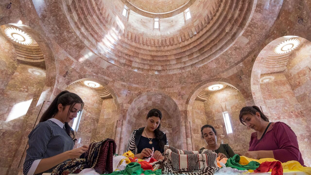 Women worshippers stand at the altar, they pray and tie knots in pieces of cloth that represent their wishes, during their visit to the new Yazidi Temple in the village of Aknalich, 35 kilometres from the Armenian capital Yerevan, on October 11, 2019.