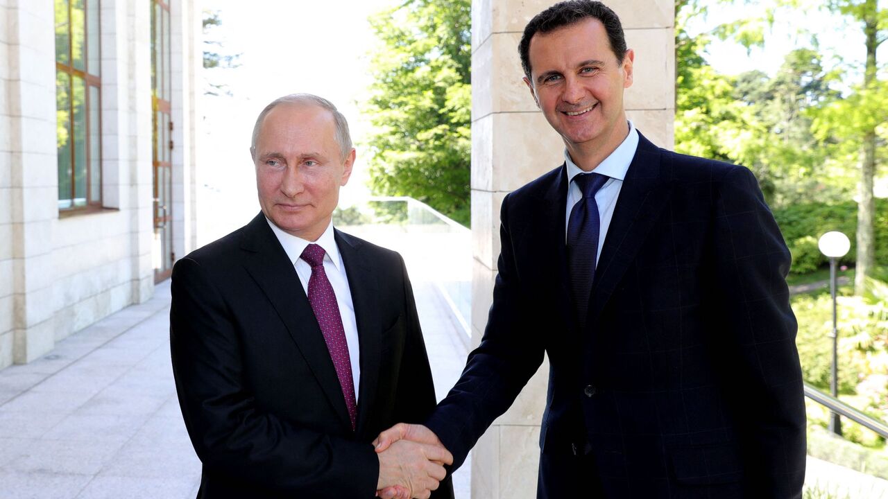 Russian President Vladimir Putin (L) shakes hands with his Syrian counterpart Bashar al-Assad during their meeting in Sochi on May 17, 2018.