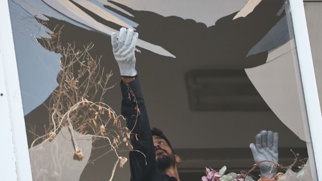 An Israeli policeman collects glass shrapnel from the window of a building that was damaged in an explosion in Tel Aviv An Israeli policeman collects glass shrapnel from the window of a building that was damaged in an explosion in Tel Aviv