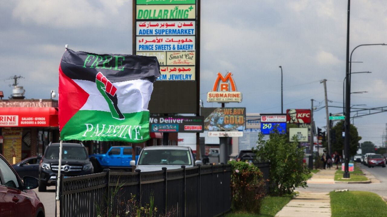 Palestinian flags flutter in the wind, shops display signs in both Arabic and English, and posters call for demonstrations against steadfast US military support of Israel 