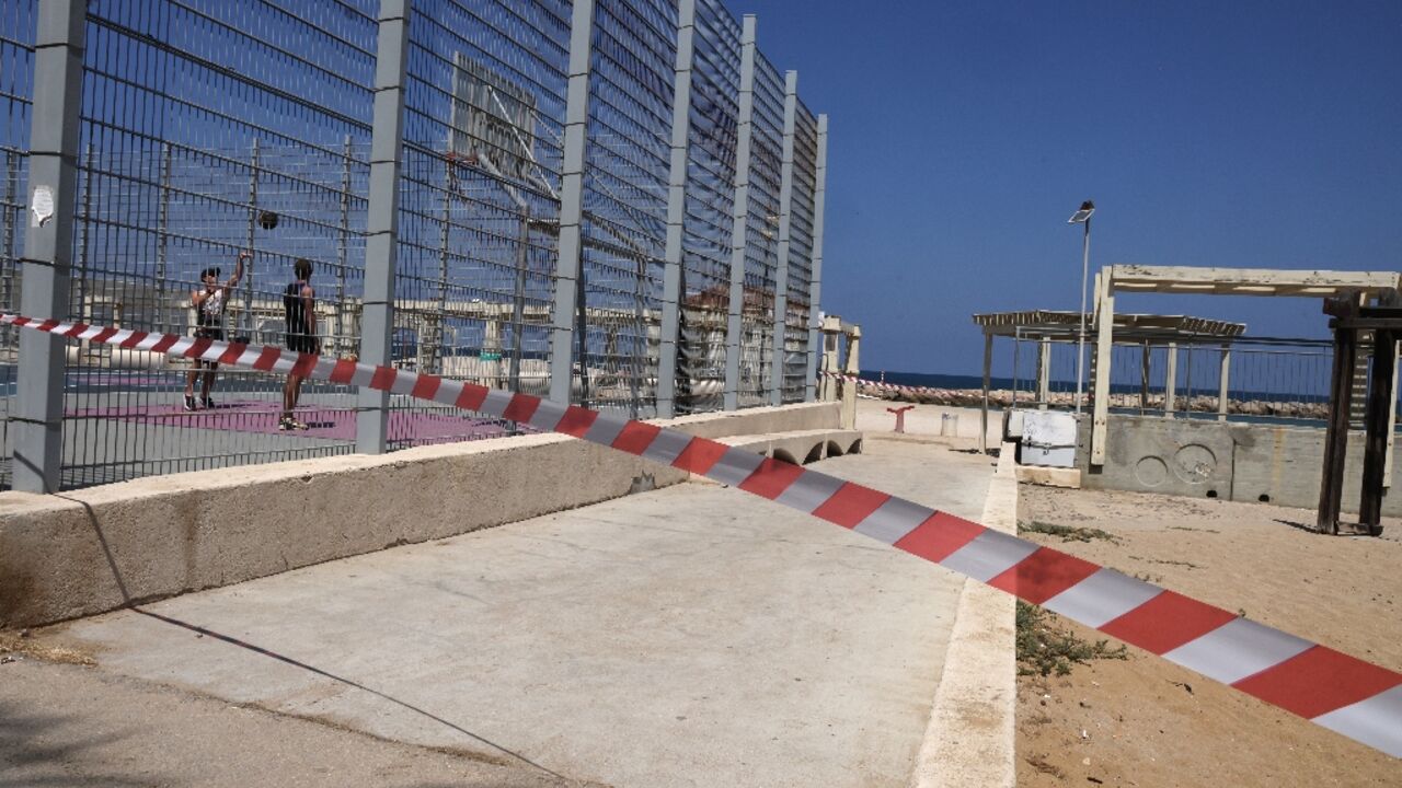 A strip of red and white tape blocks the beach entrance in the Israeli port city of Haifa during a major exchange of fire between Israeli forces and Lebanon's Hezbollah A strip of red and white tape blocks the beach entrance in the Israeli port city of Haifa during a major exchange of fire between Israeli forces and Lebanon's Hezbollah