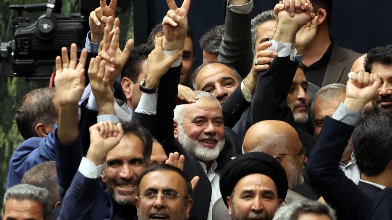 A day before his killing, Ismail Haniyeh, political chief of Palestinian militant group Hamas (C), flashes the victory sign among other officials during the swearing-in ceremony for Iran's new president A day before his killing, Ismail Haniyeh, political chief of Palestinian militant group Hamas (C), flashes the victory sign among other officials during the swearing-in ceremony for Iran's new president