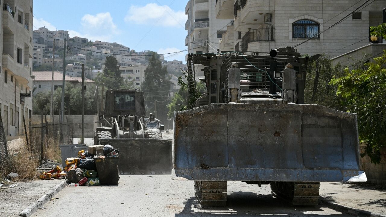 Israeli bulldozers rumble along a street in Jenin on August 31, 2024 Israeli bulldozers rumble along a street in Jenin on August 31, 2024