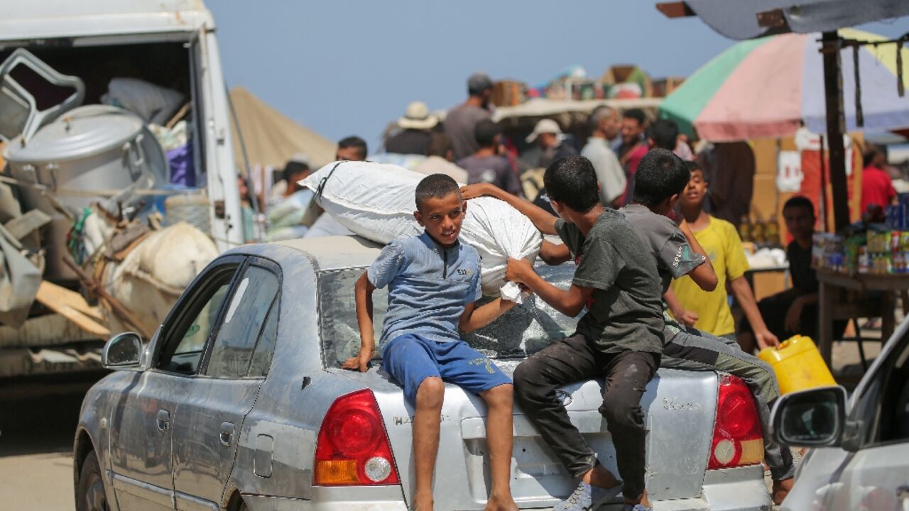 Palestinians leave the perimeter of the Al-Aqsa Martyrs Hospital in Deir el-Balah in the central Gaza Strip following an Israel order to evacuate  the area