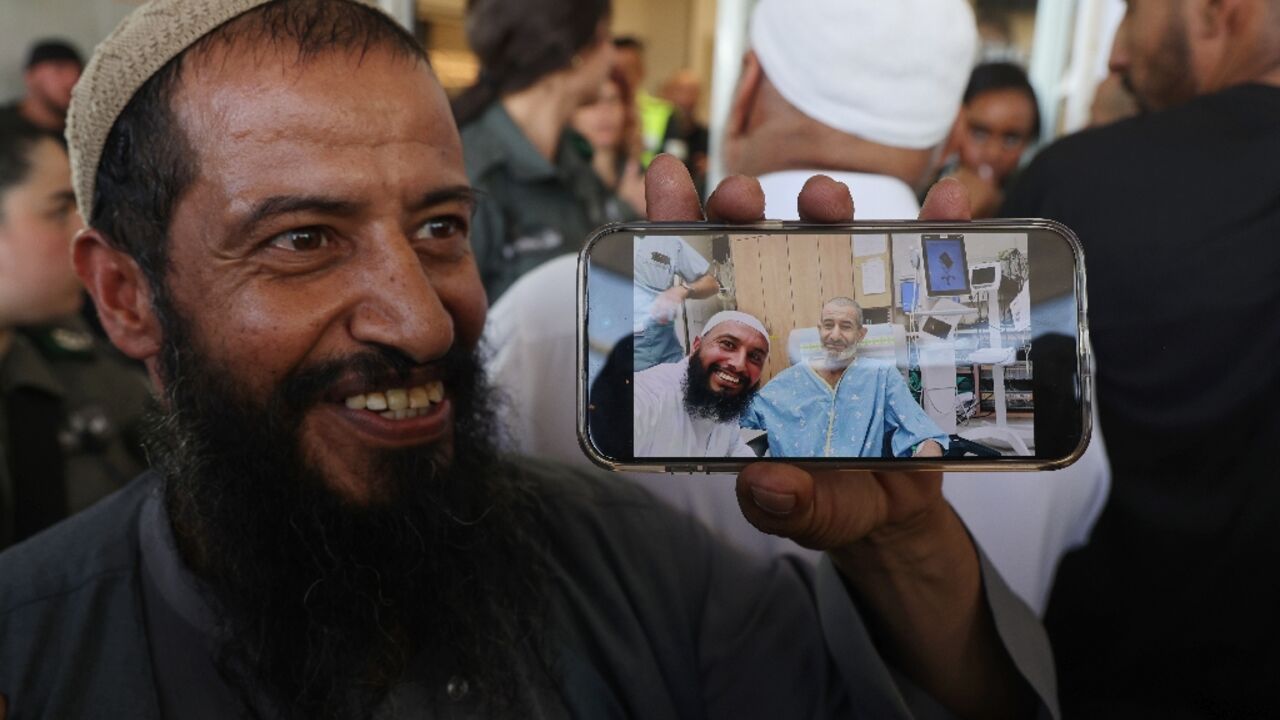 The brother of freed Israeli hostage Kaid Alkadi shows a mobile phone picture of him with another brother