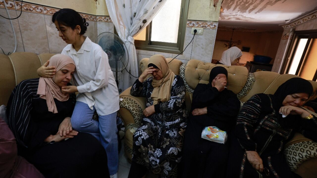 A girl comforts the mother of a Palestinian man killed during an attack by Jewish settlers on the village of Jit in the occupied West Bank A girl comforts the mother of a Palestinian man killed during an attack by Jewish settlers on the village of Jit in the occupied West Bank
