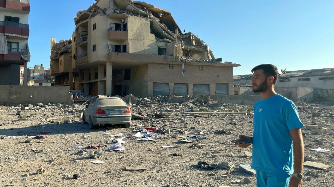 A man walks past destruction caused by Israeli air strikes on the outskirts of the city of Tyre in southern Lebanon
