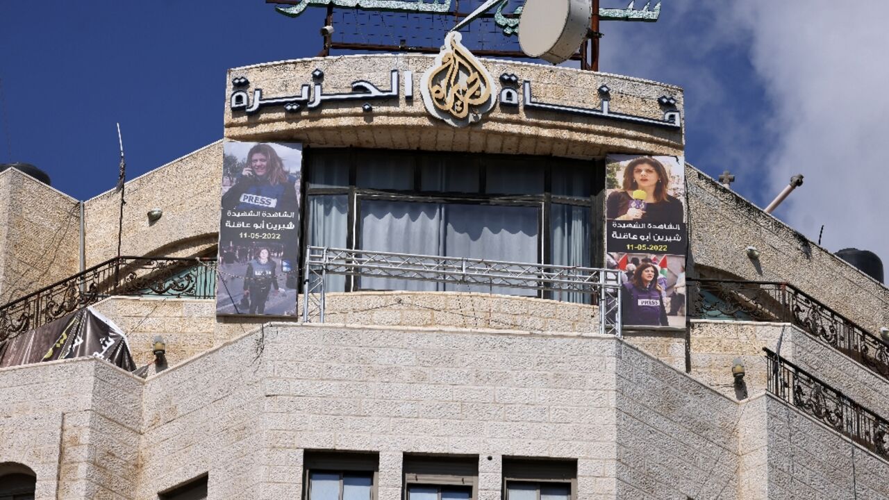 Pictures of slain Al Jazeera journalist Shireen Abu Akleh hang on the channel's office in Ramallah, in the occupied West Bank, which an Israeli court ordered shut for 45 days