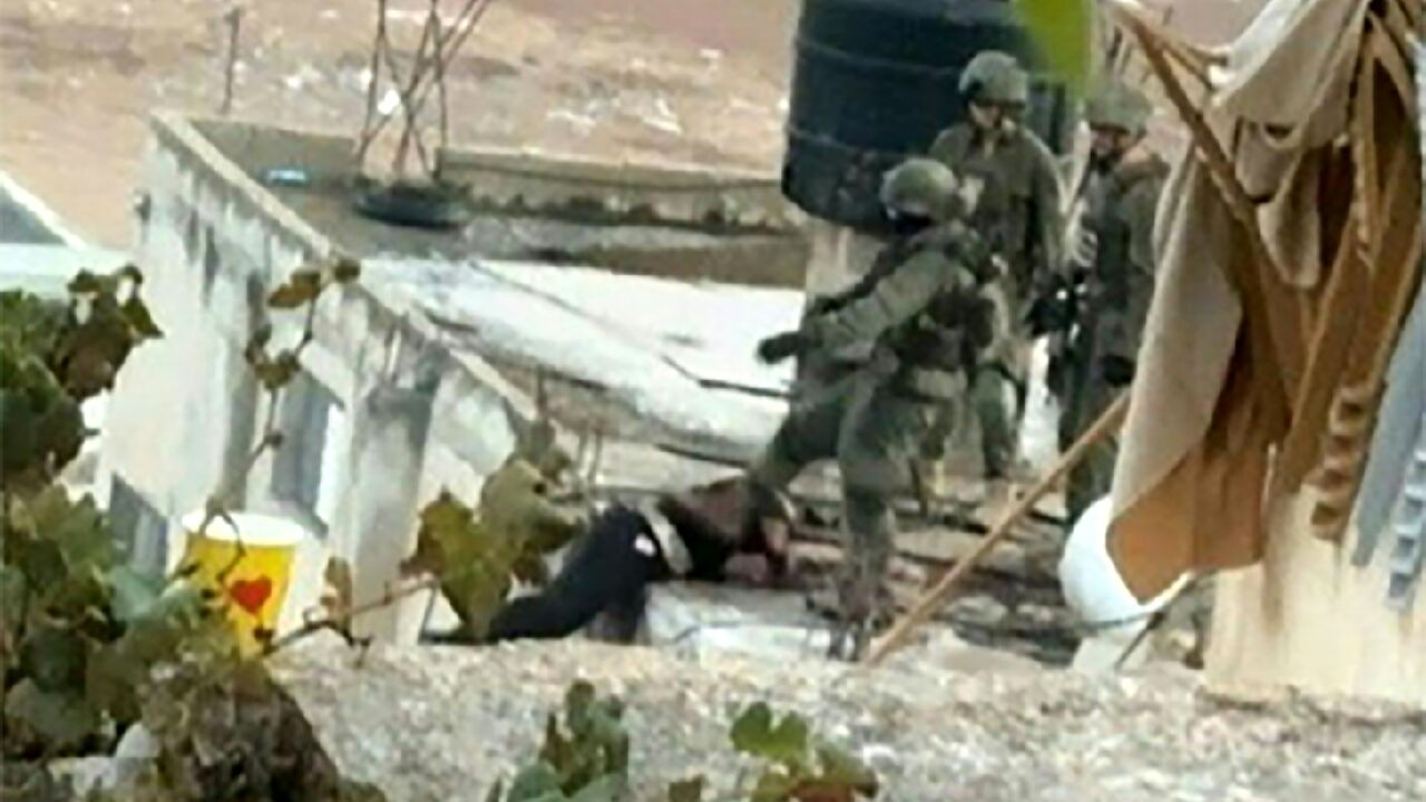 An image grab taken from an AFPTV video shows an Israeli soldier pushing an apparently dead  Palestinian off a rooftop during a raid in the occupied West Bank