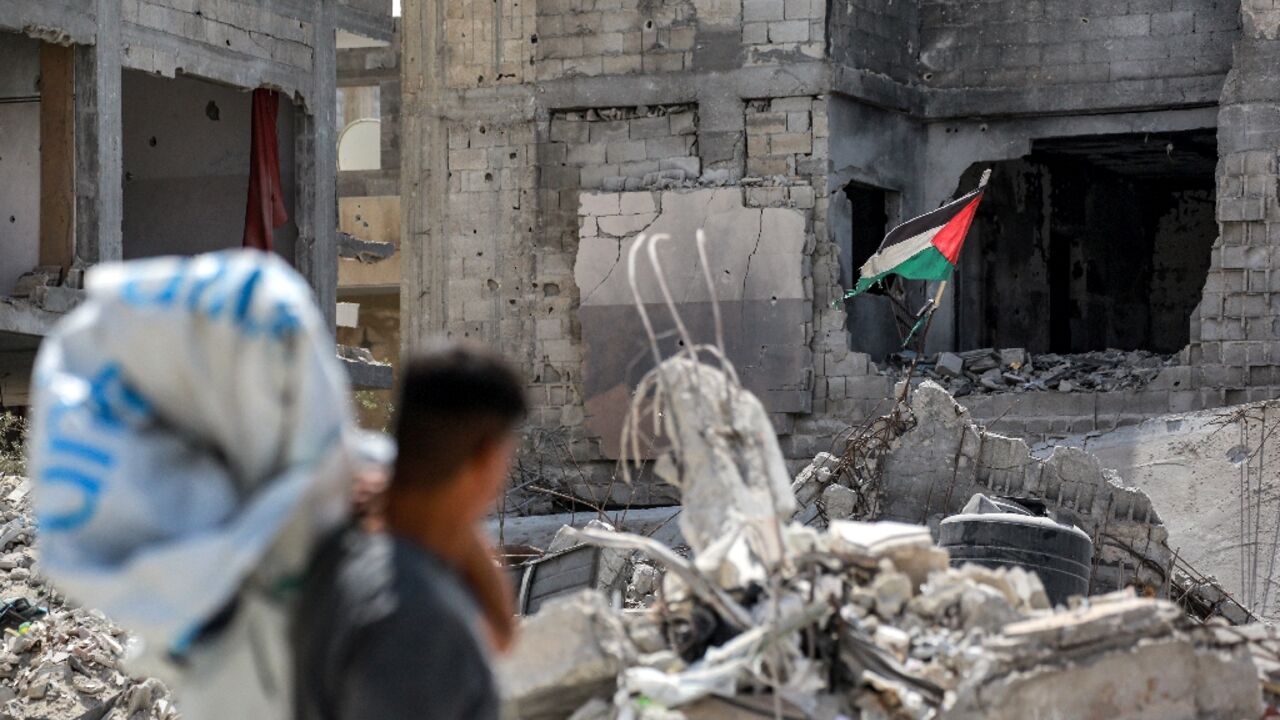 A tattered Palestinian flag flying in a ruined building in southern Gaza's Khan Yunis, nearly a year into the war