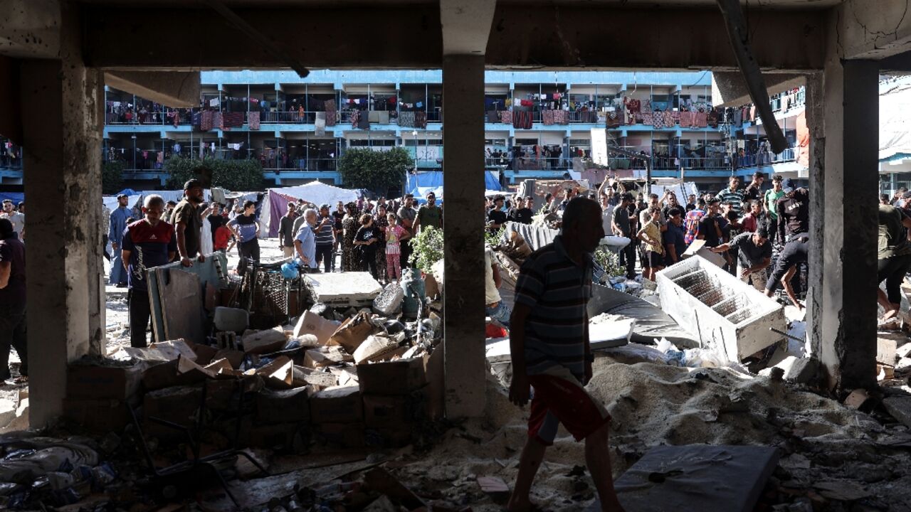 Palestinians survey the Al-Jawni school in central Gaza after an Israeli air strike Palestinians survey the Al-Jawni school in central Gaza after an Israeli air strike