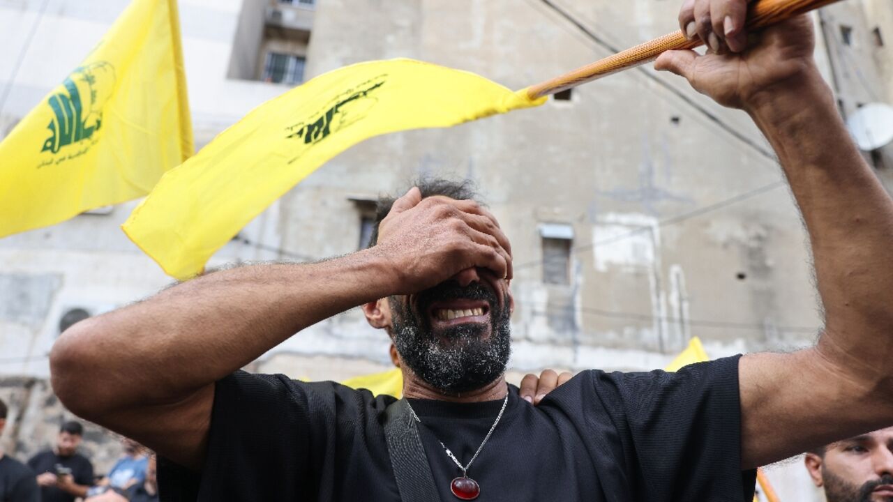 A Lebanese man clutching a Hezbollah flag is seen at funeral for people killed in pager attacks A Lebanese man clutching a Hezbollah flag is seen at funeral for people killed in pager attacks