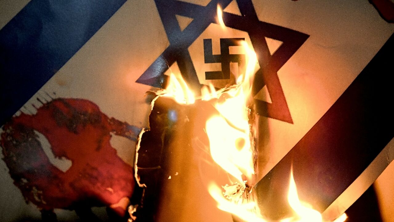 An Israeli flag with a swastika superimposed on the Star of David is burned at a pro-Palestinian protest in Istanbul