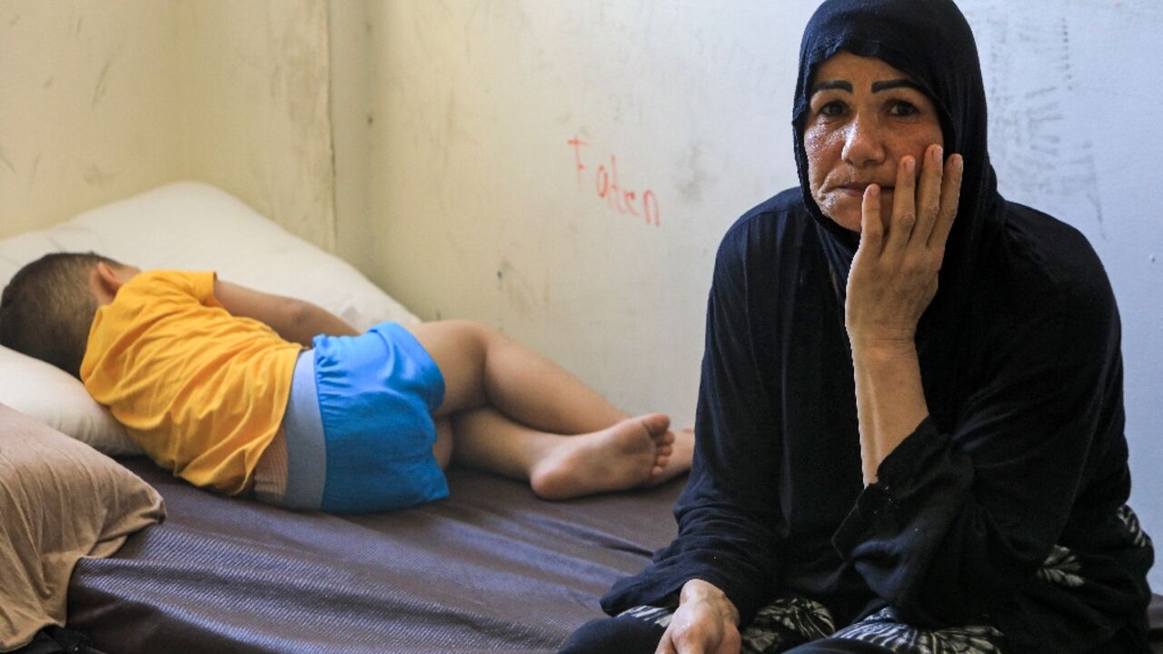 A child and a woman displaced by conflict from southern Lebanon take refuge at a school-turned-shelter in Beirut