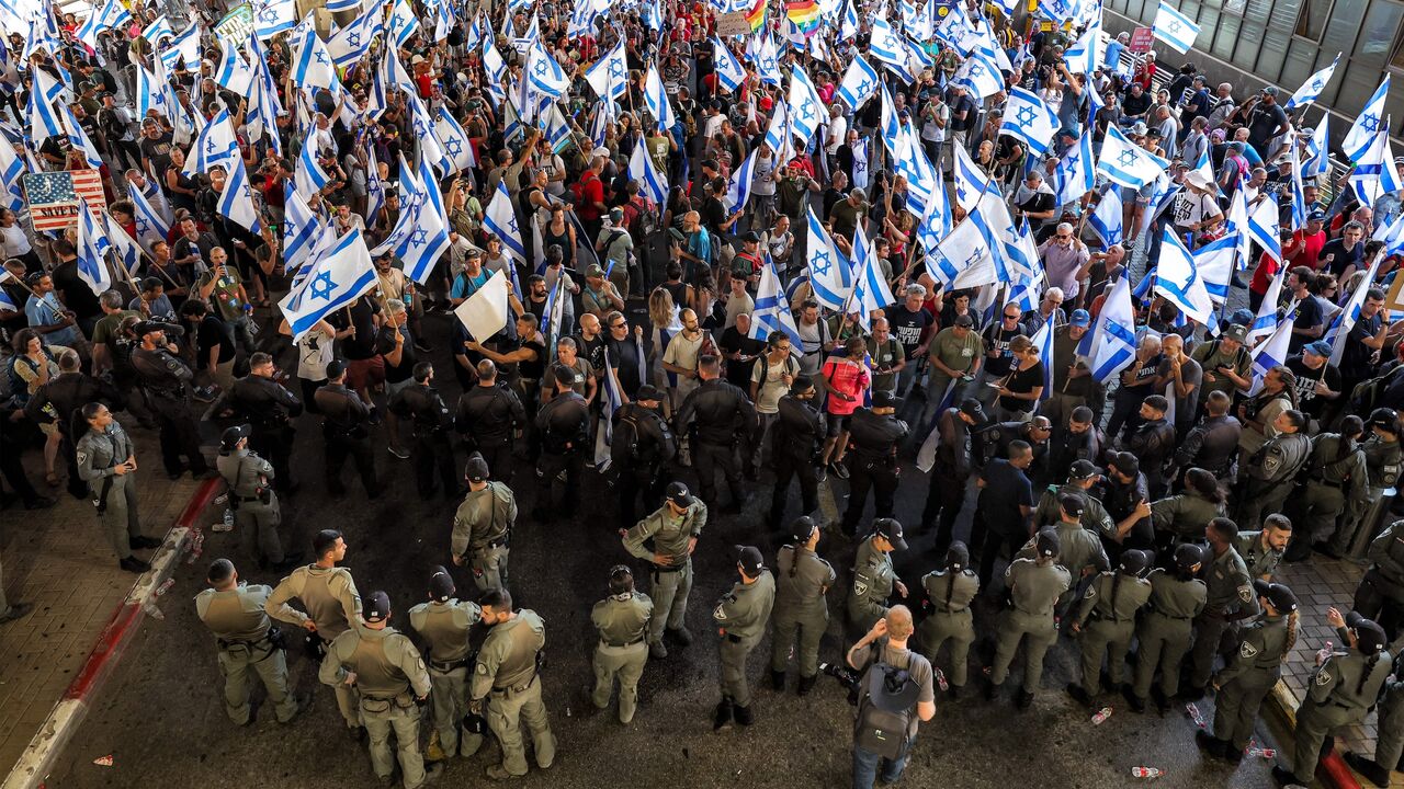 Israeli border guards stand alert as anti-government demonstrators rally with national and pride rainbow flags at Ben Gurion Airport, near Lod, during a protest hours after parliament adopted a key clause of the government's judicial overhaul package at the first reading, July 11, 2023.