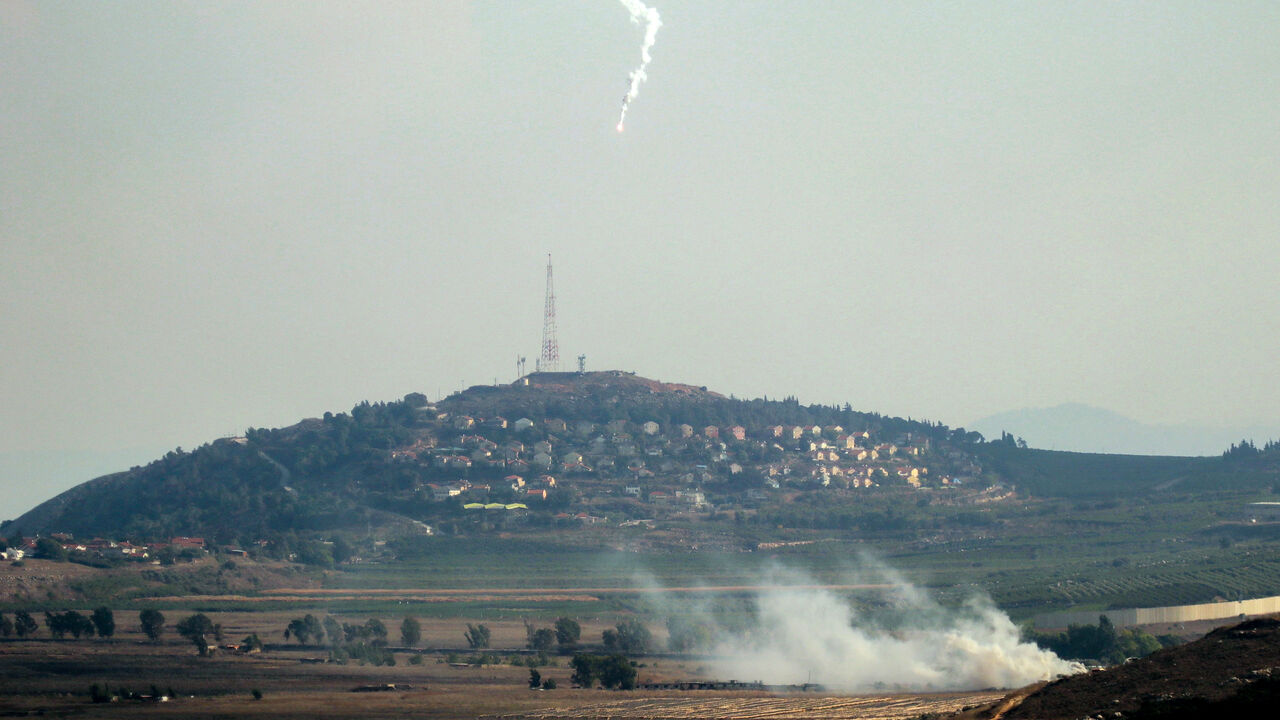 Smoke rises and a flare is deployed in the southern Lebanese Marjayoun plain after being hit by Israeli shelling on Sept. 7, 2024, amid the ongoing cross-border clashes between Israeli troops and Hezbollah fighters.